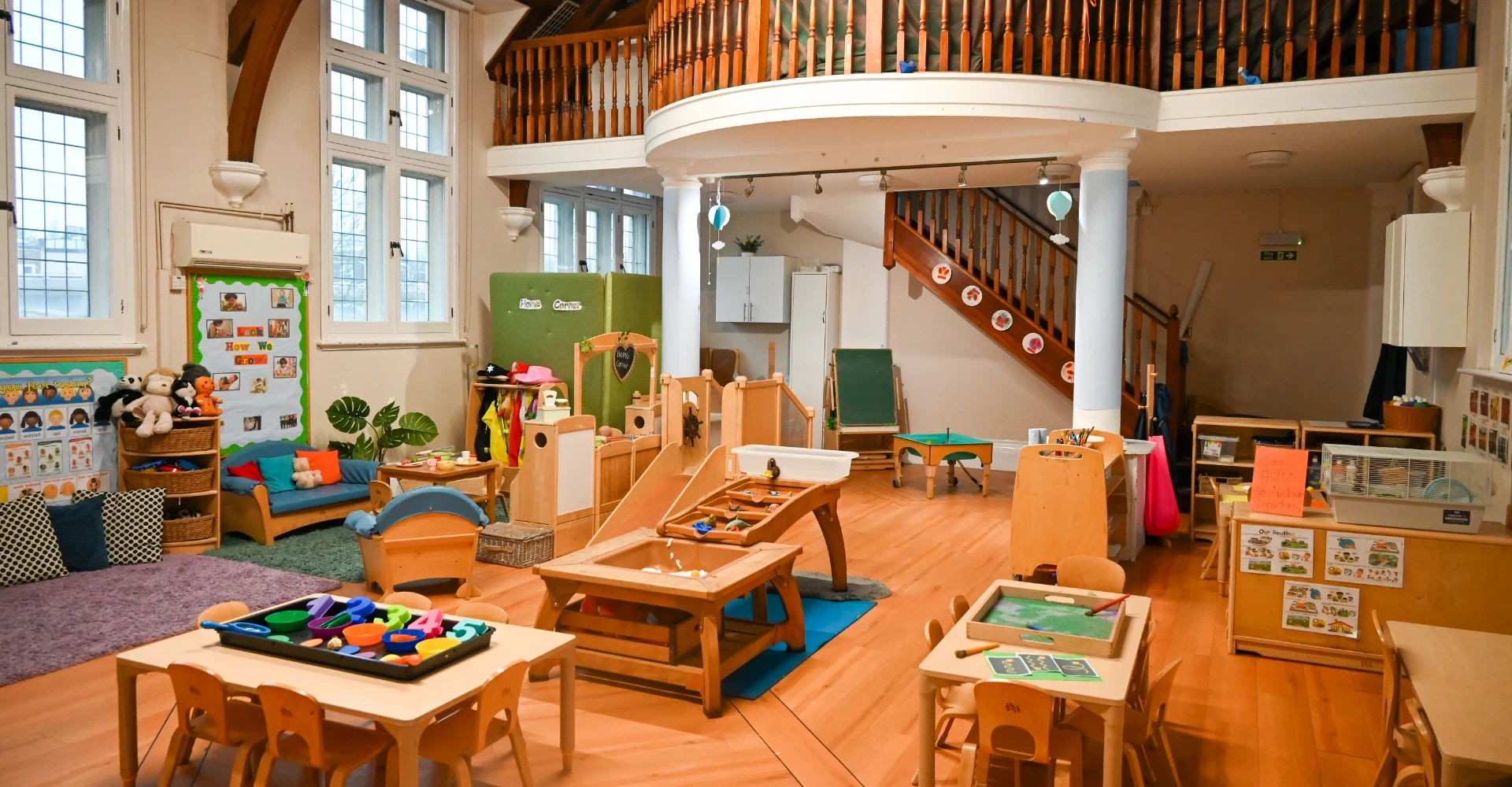 Colourful nursery classroom with wooden furniture and toys.